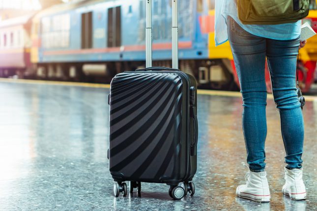 Solo woman backpacker traveler plan safety trip low cost budget summer holiday after coronavirus. Empty tourist on train railway platform. Use bus train sustainable environmental friendly transport